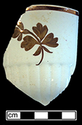 Cup with copper luster Tea Leaf motif and ribbed molded motif along lower portion of cup. Produced by a number of potters, this pattern appeared in the 1850s, remaining popular for almost half a century (Upchurch 1995; Wetherbee 1996:153). Rim diameter: 4.00”, Vessel #:79. 18BC56